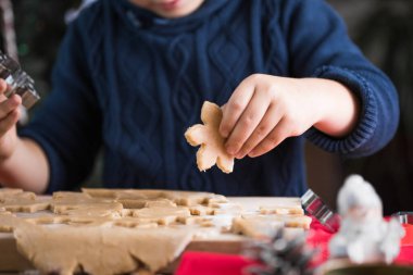 Küçük tatlı çocuk Noel kurabiyelerini yeni yıl mutfağında yapıyor..