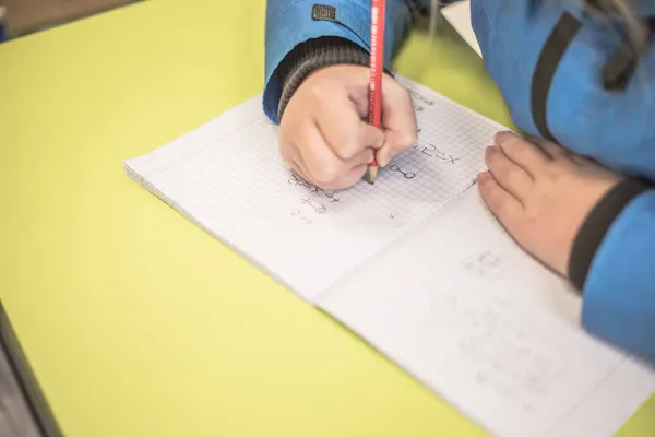 Dziecko Przygotowuje Lekcje Przy Stole Dziewczyna Pisze Notatniku Szkoła Biurkami — Zdjęcie stockowe