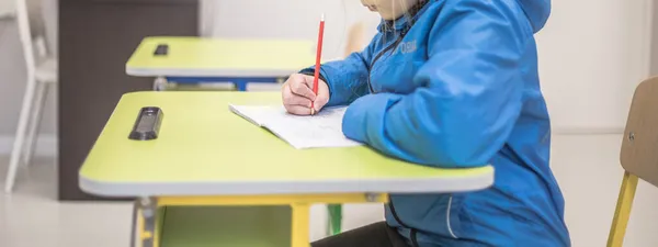 Dziecko Przygotowuje Lekcje Przy Stole Dziewczyna Pisze Notatniku Szkoła Biurkami — Zdjęcie stockowe