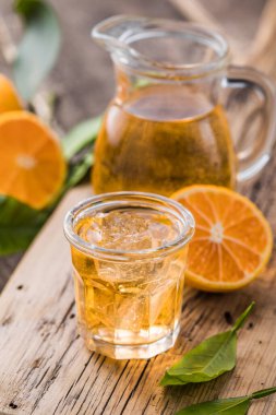 Geleneksel ev yapımı portakal likörü limoncello ve ahşap bir masada taze narenciye..