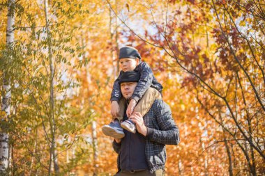 Baba oğul sonbahar parkında kucaklaşıyorlar, sığ alan derinliği. Aktif aile tatili