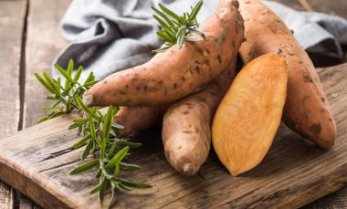 Tahta arka planda tatlı patates, yakın plan. Çiğ patates ya da otlu yarasa.