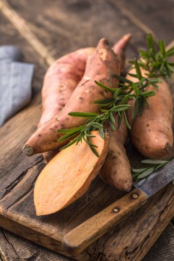 Tahta arka planda tatlı patates, yakın plan. Çiğ patates ya da otlu yarasa.