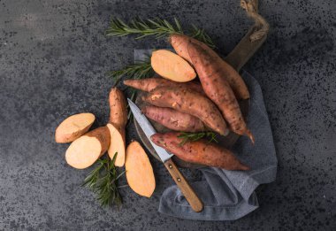 Tahta arka planda tatlı patates, yakın plan. Çiğ patates ya da otlu yarasa.