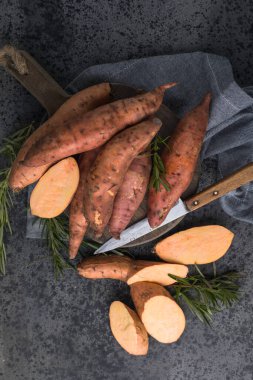 Tahta arka planda tatlı patates, yakın plan. Çiğ patates ya da otlu yarasa.