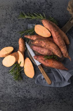 Tahta arka planda tatlı patates, yakın plan. Çiğ patates ya da otlu yarasa.