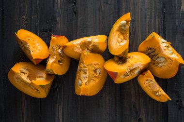 Yeşil arka planda balkabağı dilimi, yakın plan. Organik tarım ürünü, yemek malzemeleri, sağlıklı gıda vejetaryeni.