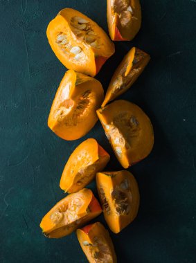 Yeşil arka planda balkabağı dilimi, yakın plan. Organik tarım ürünü, yemek malzemeleri, sağlıklı gıda vejetaryeni.