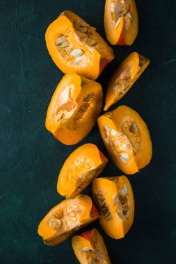 Yeşil arka planda balkabağı dilimi, yakın plan. Organik tarım ürünü, yemek malzemeleri, sağlıklı gıda vejetaryeni.