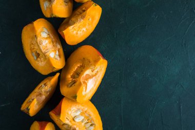 Yeşil arka planda balkabağı dilimi, yakın plan. Organik tarım ürünü, yemek malzemeleri, sağlıklı gıda vejetaryeni.