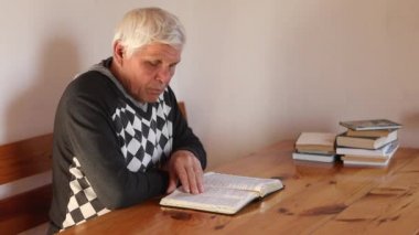 Son sınıf öğrencisi dua ediyor, elinde eski bir İncil okuyor..