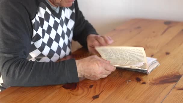 Senior man läser en bok. Avslappnande, fritid, utbildning. — Stockvideo