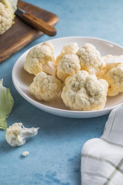 Çiğ karnabahar, mavi bir arka planda, ışık kabında fotokopi alanı olan dilimler..