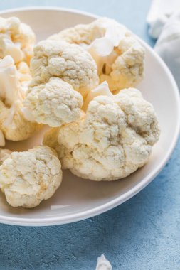 Çiğ karnabahar, mavi bir arka planda, ışık kabında fotokopi alanı olan dilimler..