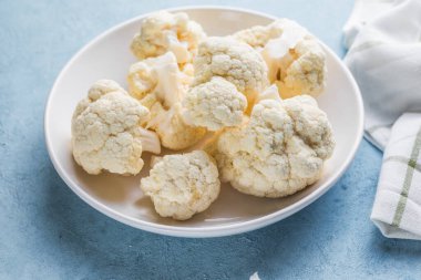 Çiğ karnabahar, mavi bir arka planda, ışık kabında fotokopi alanı olan dilimler..