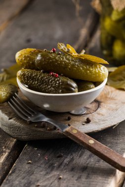 Turşu, tahtadan arka planda mayalanmış salatalık turşusu. Ev yapımı ekşi salamura sebze.