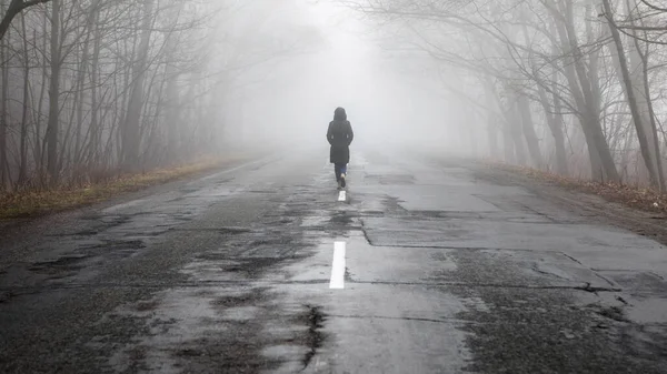 Eenzame Vrouw Loopt Weg Mistige Mistige Weg Een Dramatische Mystieke — Stockfoto