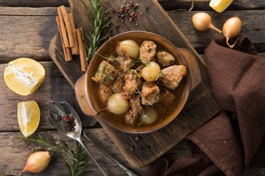 stifado - lezzetli Akdeniz sığır güveci soğan soğanları, tarçın ve baharatlar bir güveçte, siyah ahşap bir masa üzerinde, yukarıdan görüş, yakın çekim