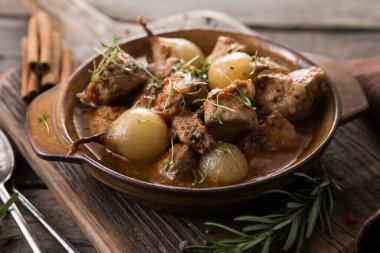 stifado - lezzetli Akdeniz sığır güveci soğan soğanları, tarçın ve baharatlar bir güveçte, siyah ahşap bir masa üzerinde, yukarıdan görüş, yakın çekim