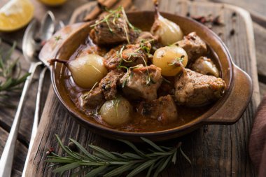 stifado - lezzetli Akdeniz sığır güveci soğan soğanları, tarçın ve baharatlar bir güveçte, siyah ahşap bir masa üzerinde, yukarıdan görüş, yakın çekim