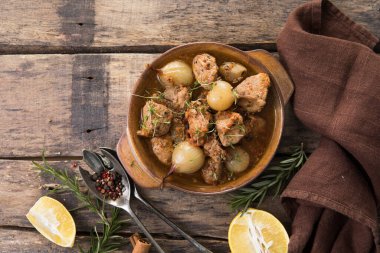 stifado - lezzetli Akdeniz sığır güveci soğan soğanları, tarçın ve baharatlar bir güveçte, siyah ahşap bir masa üzerinde, yukarıdan görüş, yakın çekim