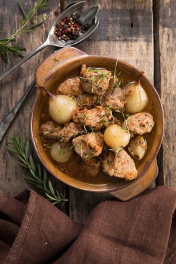 stifado - lezzetli Akdeniz sığır güveci soğan soğanları, tarçın ve baharatlar bir güveçte, siyah ahşap bir masa üzerinde, yukarıdan görüş, yakın çekim