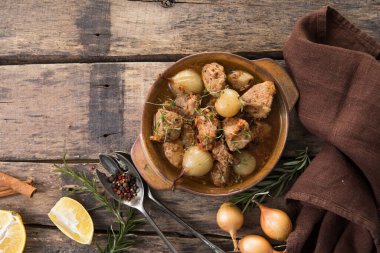 stifado - lezzetli Akdeniz sığır güveci soğan soğanları, tarçın ve baharatlar bir güveçte, siyah ahşap bir masa üzerinde, yukarıdan görüş, yakın çekim