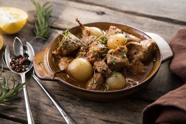 stifado - lezzetli Akdeniz sığır güveci soğan soğanları, tarçın ve baharatlar bir güveçte, siyah ahşap bir masa üzerinde, yukarıdan görüş, yakın çekim