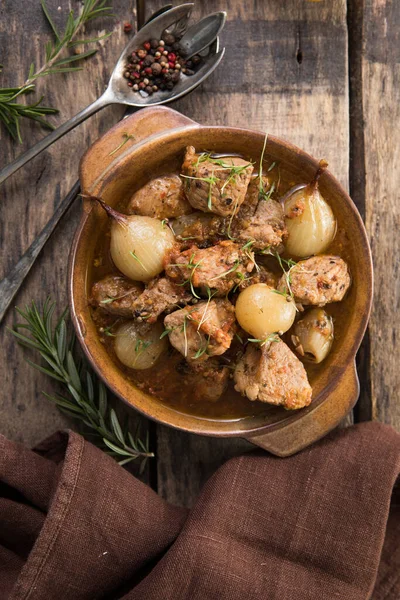 stifado - lezzetli Akdeniz sığır güveci soğan soğanları, tarçın ve baharatlar bir güveçte, siyah ahşap bir masa üzerinde, yukarıdan görüş, yakın çekim