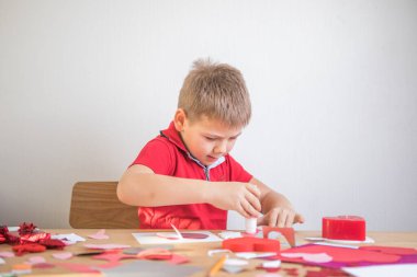 Kırmızı kağıt kalpli DIY tatil kartı, aşkın sembolü. Çocuk Anneler Günü 'nde, Sevgililer Günü' nde, tebrik kartında. Hobi, çocuk sanatı konsepti, kendi ellerinle hediye, çocuklar için fikirler.