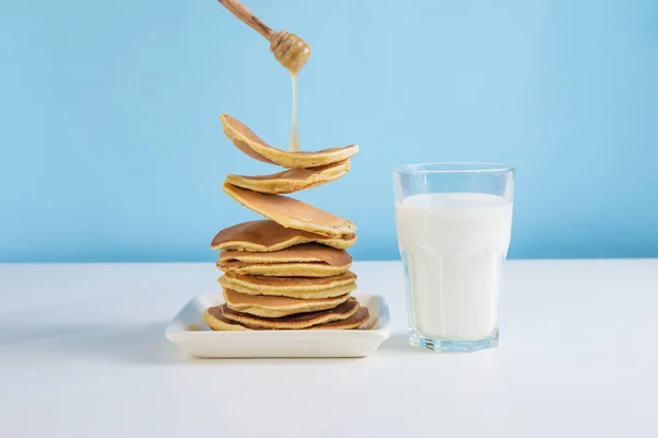 Pila Levitante Panqueques Con Miel Vaso Leche Sobre Fondo Azul — Foto de Stock