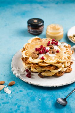 Yeni pişirilmiş ev yapımı kalp şeklinde Belçika waffle 'ı mavi arka planda. Avrupa usulü hamur tatlısı. Sevgililer Günü kahvaltı konsepti.