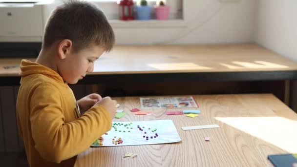 Little boy being creative making homemade do it yourself dinosaur mosaic. — Stockvideo