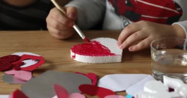 The child draws on foam heart. Creative development of children. Valentines Day 