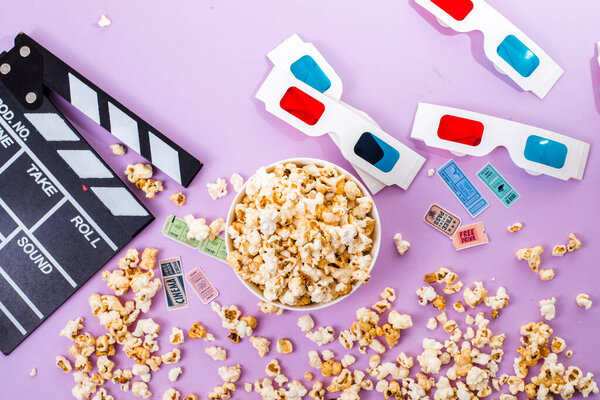 popcorn, 3d glasses and movie tickets top view flat lay on purple solid background