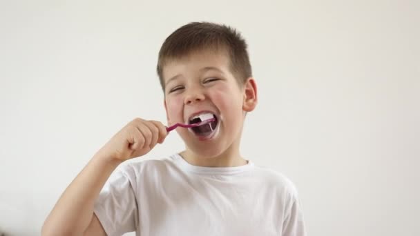 Niño niño cepillándose los dientes usando cepillo de dientes y pasta oral, limpiando los dientes. — Vídeos de Stock