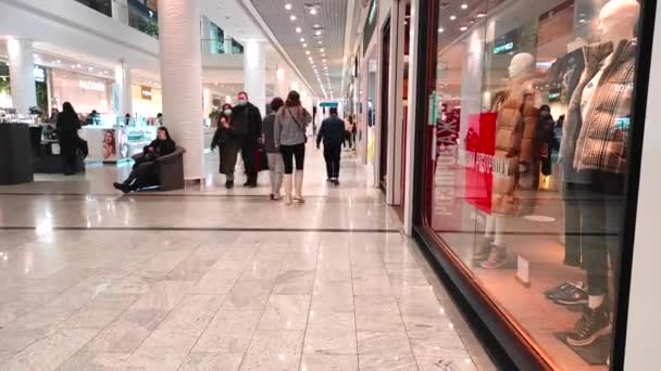 Kijev, Ukrajna 2022 - A modern bevásárlóközpontban sétáló emberek. Neonfények. — Stock videók