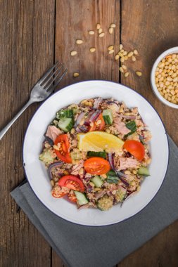 Yemek diyeti konsepti, ton balığı salatası. Konserve ton balığı, domates, salatalık ve mor soğanlı kuskus salatası. Boşluğu kopyala.