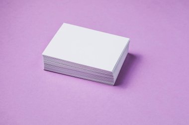 Beyaz çarşaf modeli. Bir sürü boş isim kartı. Mor kağıt üzerinde boş beyaz kartvizit. 