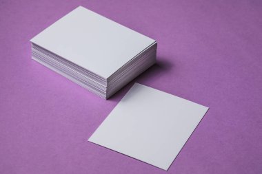 Beyaz çarşaf modeli. Bir sürü boş isim kartı. Mor kağıt üzerinde boş beyaz kartvizit. 