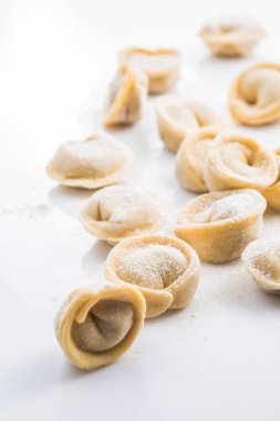 Çiğ taze hamur köftesi ya da beyaz arka planda izole edilmiş İtalyan tortellini makarna.