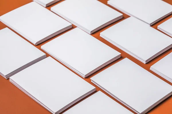 White sheet mockup. Stack of blank name cards. Blank white business card on brown paper background.