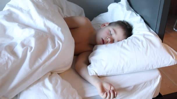 寝たきりの幼児の少年がベッドに横になって泣いている ベッドルームで疲れた子供 — ストック動画