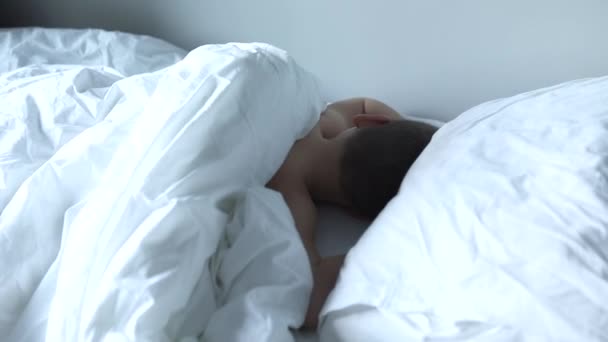 Aranyos fiú alszik az ágyban a reggeli fény, szép gyermek kap mély alvás. — Stock videók