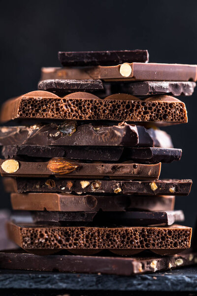 Шоколадная башня. Хэйзелнат и миндальные тёмные куски разбитого шоколада. Концепция фотографии сладкой пищи.