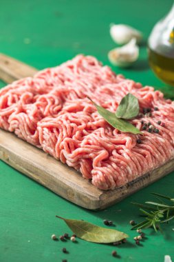 Çiğ kıyma, kıyma dilimlenmiş et. Yeşil arka plan. Üst görünüm