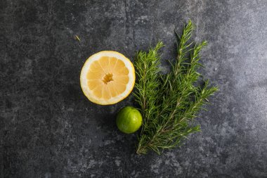 Siyah masada biberiye ve limon dilimleri. Boşluğu kopyala.
