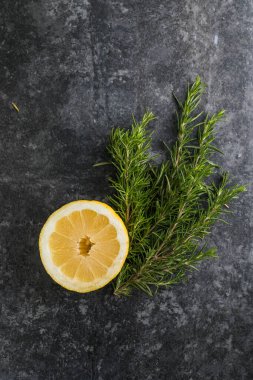 Siyah masada biberiye ve limon dilimleri. Boşluğu kopyala.