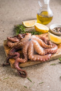 Tahtada servis edilen doğranmış bitkilerle pişirilmiş ahtapot.