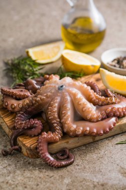 Tahtada servis edilen doğranmış bitkilerle pişirilmiş ahtapot.